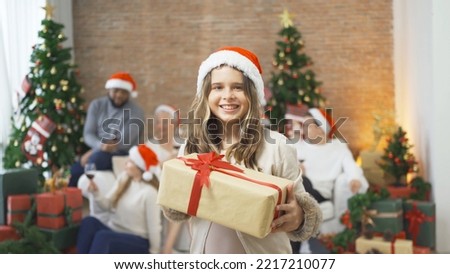 Portrait of a multi ethnic caucasian family, woman, father, mother and kid girl with present gift in party on Merry Christmas Eve Xmas on holiday. Celebration at home. People lifestyle. Thanksgiving