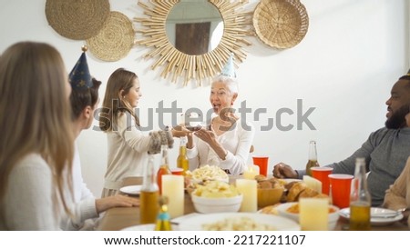 A group of multi ethnic. Portrait of Caucasian and African American black family, woman have a happy birthday cake celebration dinner in party on holiday at home.People lifestyle.