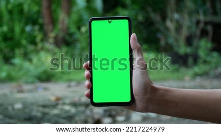 Close-up view of a young man in a park and using a smartphone. The concept of using a smartphone in outdoors. 