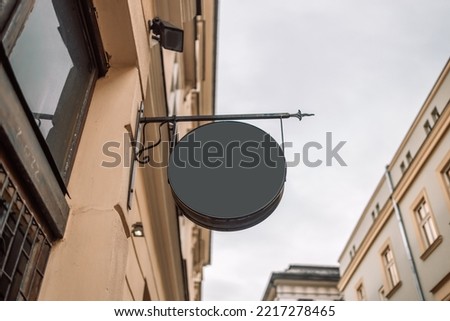 Blank black round store signboard Mockup. Empty circular illuminated shop lightbox template mounted on wall. Mock up of illuminated blank signboard. Place for text, outdoor advertising, banner 