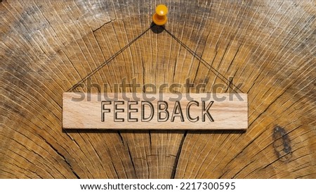 The word feedback is written on the wooden surface. wooden surface in background.