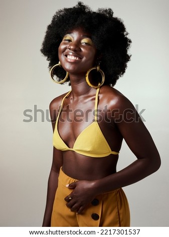 Beauty, black woman and portrait with afro and bikini fashion top showing glowing skin in studio. Happy, cheerful and edgy african girl with natural hair and trendy yellow makeup with mockup.
