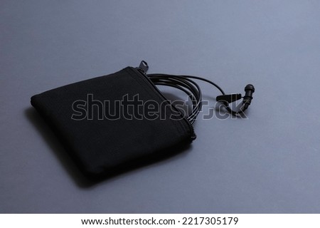 zipped cloth bag with a studio microphone lavalier. Shallow depth of field