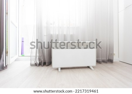 Modern electric infrared heater in living room Royalty-Free Stock Photo #2217319461