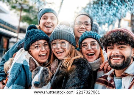 Multiracial smiling friends taking selfie shot smiling at camera - Laughing young people walk outdoor with a dog and having fun on the city - Concept of community, youth lifestyle and friendship