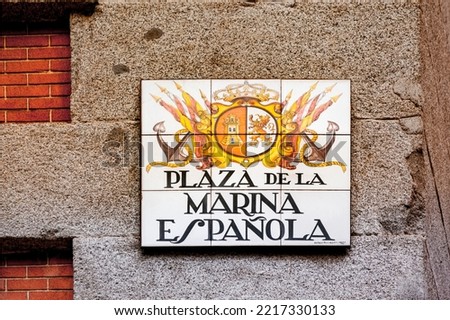 Street sign in Madrid, Spain. There are hundreds of hand painted tiles representing the street name in some way: this is the sign of the Square of Spanish Navy, written in Spanish. 