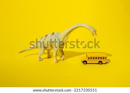Dinosaurs with school bus on a yellow background.