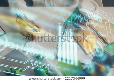 Tech theme hologram over woman's hands taking notes background. Concept of hightech. Double exposure