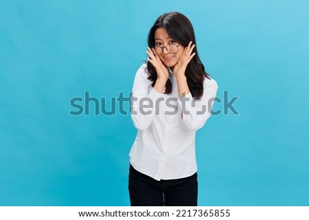Lovely Asian businesswoman in round glasses classic office dress code recline on hands posing isolated on over blue studio background. Cool business offer. Work Life Balance concept Royalty-Free Stock Photo #2217365855