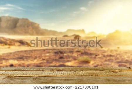 Wooden table top on blur cactus desert background.Hot weather and drink somethings for fresh.Juice and cold water.For montage product display or design key visual layout.View of copy space.