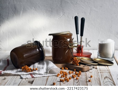 The concept of harvesting jam from healthy sea buckthorn for future use.Glass jars with jam on a wooden background.Autumn. Royalty-Free Stock Photo #2217423175