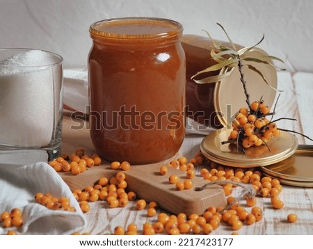The concept of harvesting jam from healthy sea buckthorn for future use.Glass jars with jam on a wooden background.Autumn. Royalty-Free Stock Photo #2217423177
