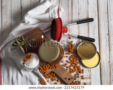 The concept of harvesting jam from healthy sea buckthorn for future use.Glass jars with jam on a wooden background.Autumn. Royalty-Free Stock Photo #2217423179