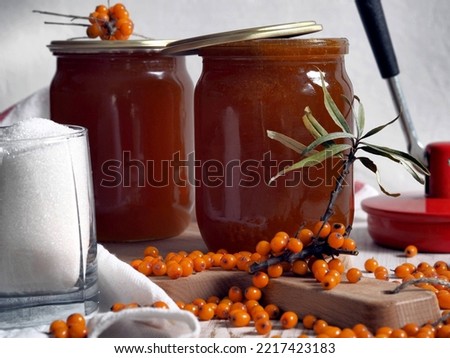 The concept of harvesting jam from healthy sea buckthorn for future use.Glass jars with jam on a wooden background.Autumn. Royalty-Free Stock Photo #2217423183