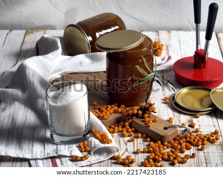 The concept of harvesting jam from healthy sea buckthorn for future use.Glass jars with jam on a wooden background.Autumn. Royalty-Free Stock Photo #2217423185