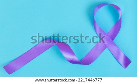 Purple ribbon on blue background ADD,ADHD,Alzheimer Disease ,Arnold Chiari Malformation,Childhood Hemiplegia stroke, Epilepsy, Chronic Acute Pain,Crohns Royalty-Free Stock Photo #2217446777