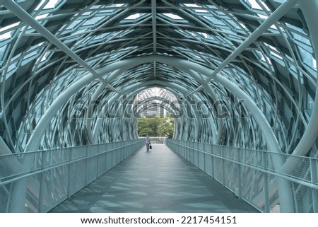 Scenic view of the pedestrian bridge Saloma Link connecting Kampung Baru with Ampang road in Kuala Lumpur. A person can seen walking through the bridge. Royalty-Free Stock Photo #2217454151