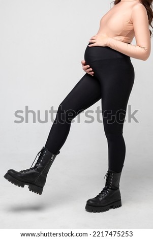 Clothes for pregnant, black pants with high waist isolated on white background, pregnancy concept.leggings for pregnant women, black tights.Special elastic band for the abdomen.