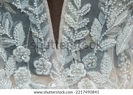 Beautiful bridal dress on hangers. Embroidery with beads. Wedding dress close up at the wedding salon. Wedding dresses hanging on a hanger. Royalty-Free Stock Photo #2217490841