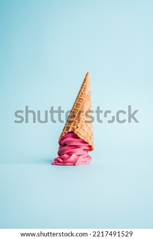 Pink Ice Cream cone upside down, minimal blue background Royalty-Free Stock Photo #2217491529