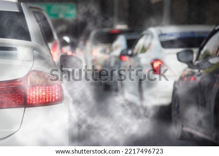 Air pollution from car exhaust smoke traffic in the city. Reducing global warming pollution and carbon dioxide from engine combustion. Royalty-Free Stock Photo #2217496723