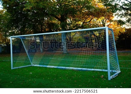 Football empty gate and green field on the autumn background