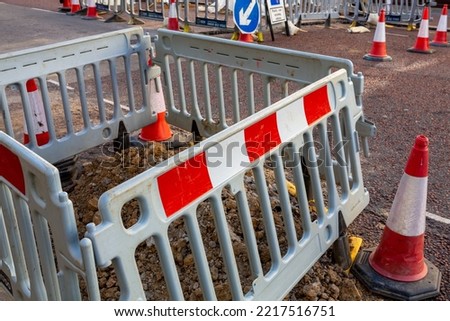Road works with safety barriers, traffic cones and directional signs
