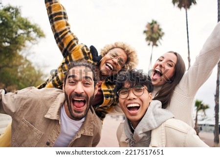 Cheerful people having fun. Happy young multiracial friends from diverse cultures and races taking selfie outdoors. High quality photo