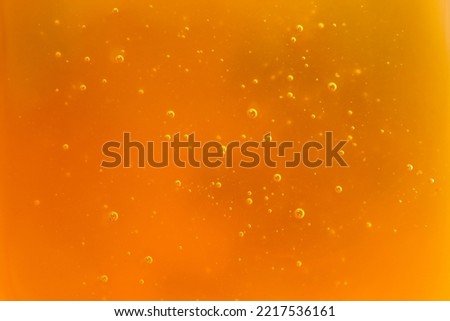 Texture of natural golden honey with air bubbles as a background. Free space for text.