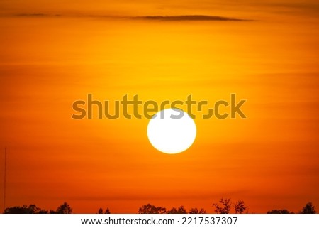 Beautiful sunset, full of the sun On the red background of the sunset light,Denote the end of the day.sunset and sunrise concept.Safari theme. The big sun set Real image Royalty-Free Stock Photo #2217537307