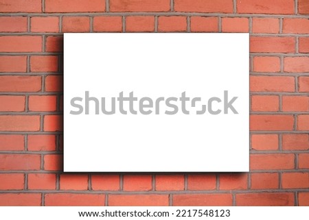 Square white blank signage with space for mock up hanging in red brick wall closeup