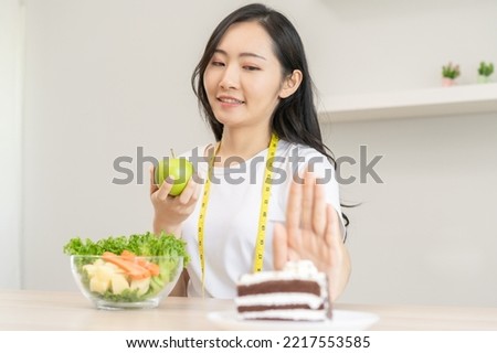 Diet, Dieting asian young woman using hand push out, deny chocolate cake or sweet taste, dessert food, choose eat green salad vegetables when hungry. Nutritionist of healthy, nutrition of weight loss. Royalty-Free Stock Photo #2217553585