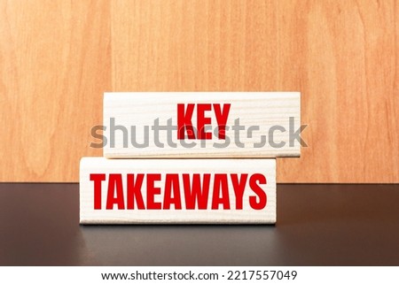 Two wooden blocks with the text KEY TAKEAWAYS on a light wooden background
