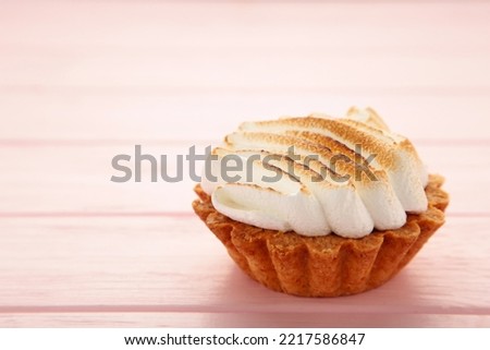 Appetizing lemon cupcake with white cream on pink background. Holiday, surprise, birthday, Valentine's Day. Top view.
