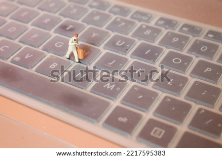 miniature figure of an office worker who is in a hurry walking on a keyboard. office worker concept.