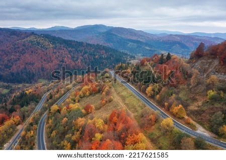 Scenic aerial view of the colorful autumn wooded mountains and mountain pass, nature landscape, Carpathians. Outdoor travel background