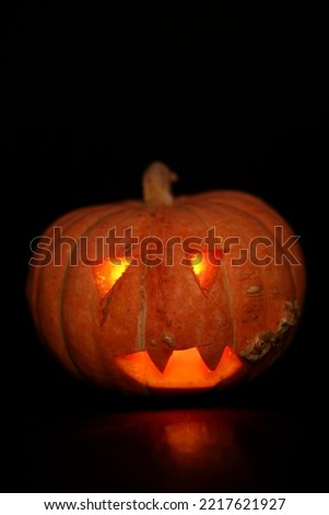 spooky concept - jack-o-lantern with burning eyes on black background. Halloween concept