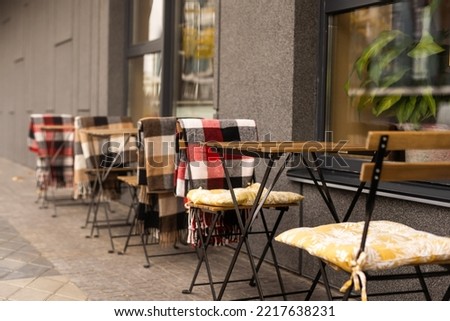 comfy seats in a street cafe with blankets Royalty-Free Stock Photo #2217638231