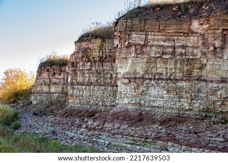 Ilmensky Glint is a natural formation, a geological monument on the southern shore of Lake Ilmen. Cliff of sedimentary rocks near the village of Ustreka Royalty-Free Stock Photo #2217639503