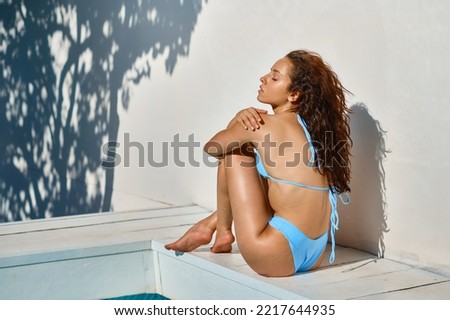 Woman sitting at poolside enjoy summer vacation