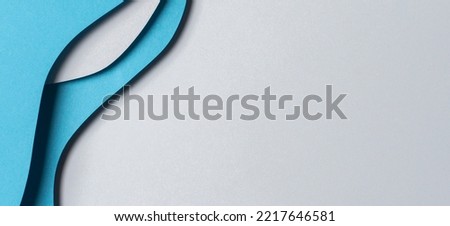 Abstract colored paper texture background. Minimal paper cut style composition with layers of geometric shapes and lines in blue hue colors. Top view. Royalty-Free Stock Photo #2217646581