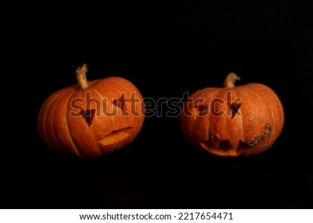 spooky concept - two jack-o-lanterns isolated on black background. Image contains copy space. Halloween concept