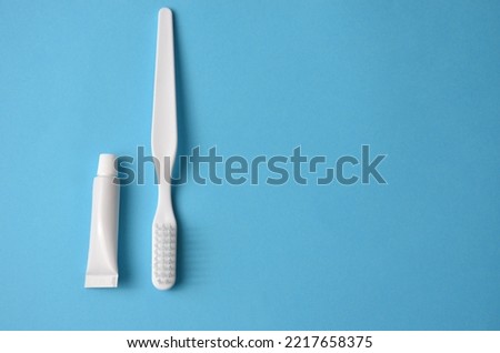 Toothbrush and tube of toothpaste on a blue background.