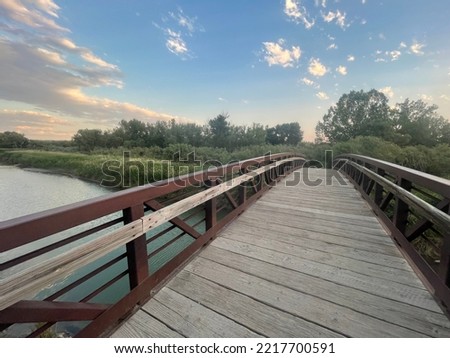 Bridge over the river at sunset in the Norm Schoenthal island park in Billings Montana Royalty-Free Stock Photo #2217700591