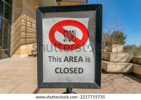 Austin, Texas- Framed signage with Stop This Area is Closed. Close-up of a sign post with a background of blurred building and sky at the background.