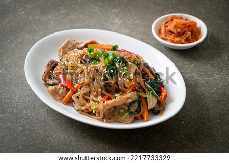 japchae or stir-fried Korean vermicelli noodles with vegetables and pork topped with white sesame - Korean traditional food style Royalty-Free Stock Photo #2217733329