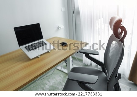 Ergonomic chair and Adjustable table with laptop computer in modern workplace. Good posture to avoid Office syndrome, Back Pain, shoulder ache, fibromyalgia and Neck pain Royalty-Free Stock Photo #2217733331
