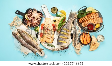 Various seafood and fishes dishes. Healthy food concept on blue background, top view Royalty-Free Stock Photo #2217746671