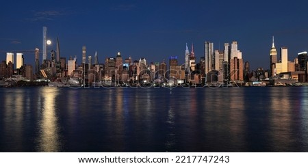 New York City at night including the moon and nice reflection on Hudson River, USA