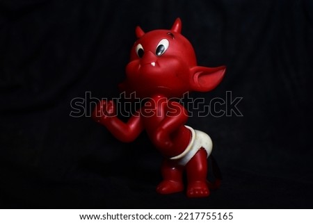 Emotional Baby Devil Figurine Isolated On Dark Background